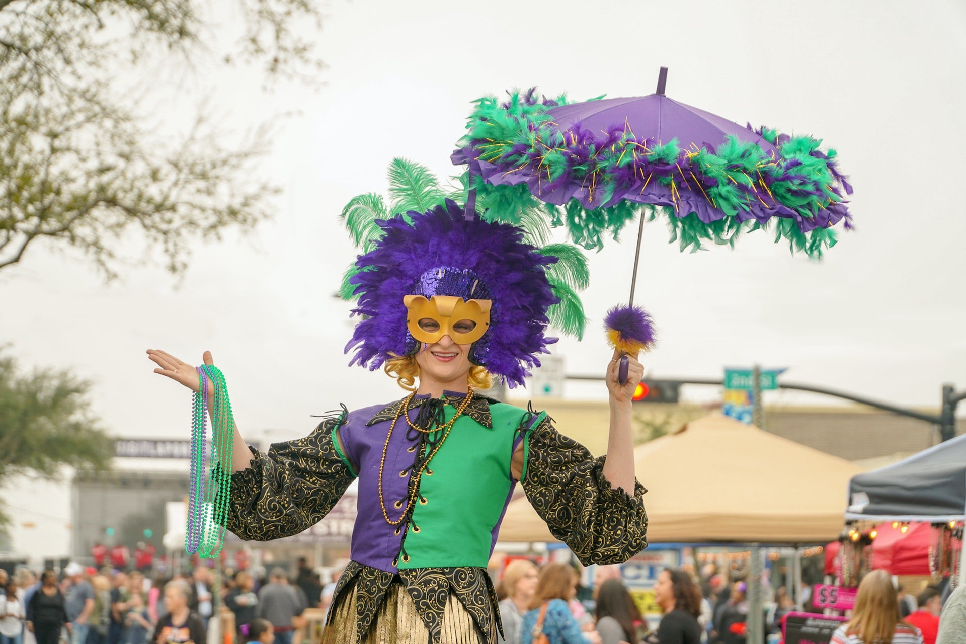 Lady dressed in Mardi Gras costume with a crowd behind her